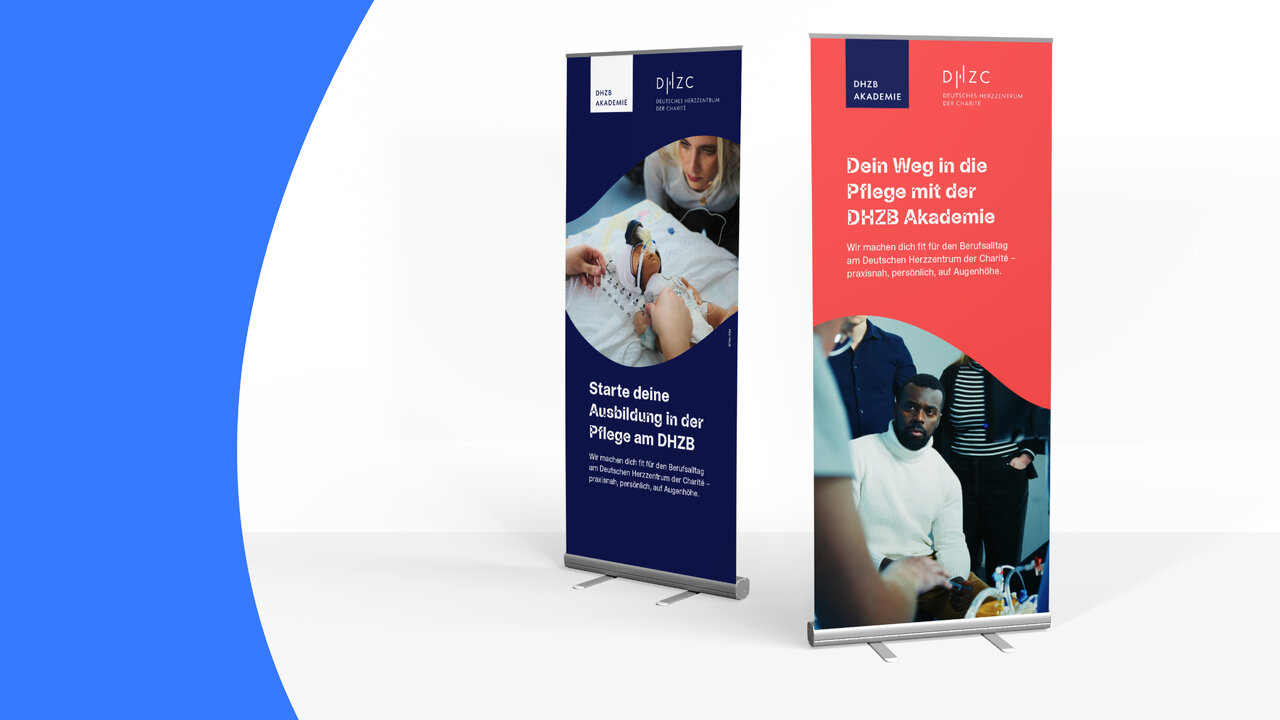Zwei Roll-up-Banner der DHZB Akademie, eines in Dunkelblau mit dem Titel &bdquo;Starte deine Ausbildung in der Pflege am DHZB&ldquo; und eines in Rot mit &bdquo;Dein Weg in die Pflege mit der DHZB Akademie&ldquo;, jeweils mit Fotos von Pflegekr&auml;ften.
