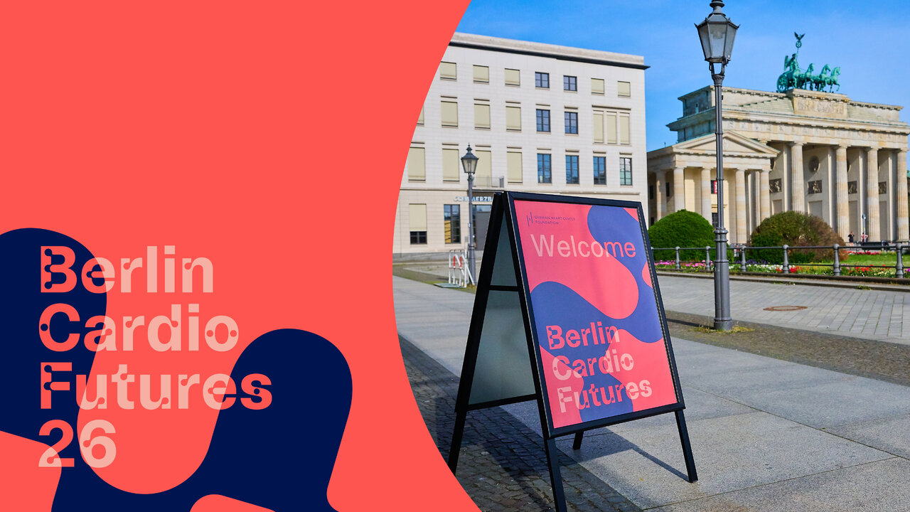 Werbeplakat f&uuml;r "Berlin Cardio Futures 26" vor dem Brandenburger Tor, mit Willkommensschild in Pink und Blau. Links im Bild ein roter Bereich mit dem Veranstaltungstitel und einer stilisierten dunkelblauen Grafikform.